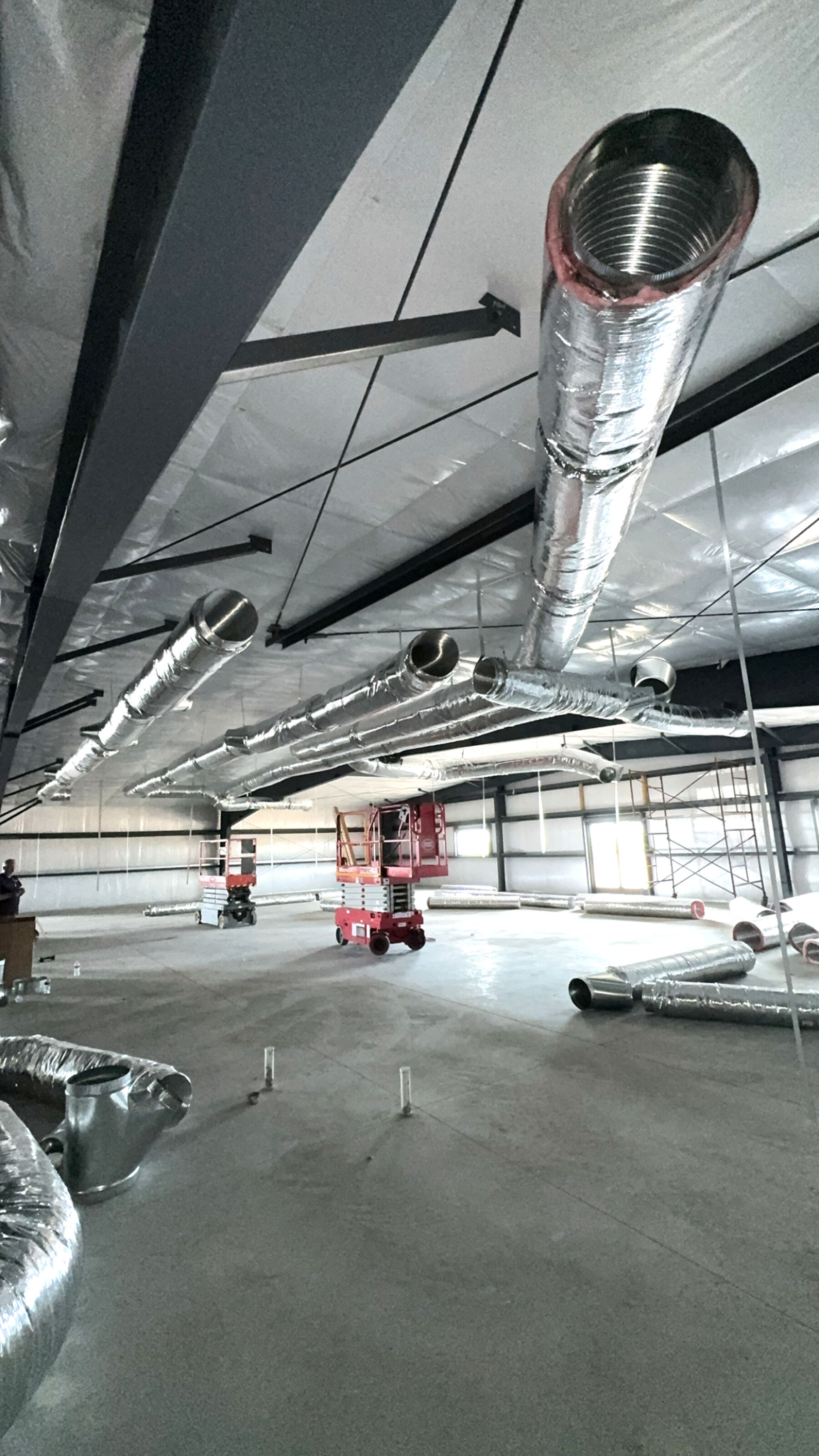 Commercial ductwork installation with spiral trunk and flex runouts